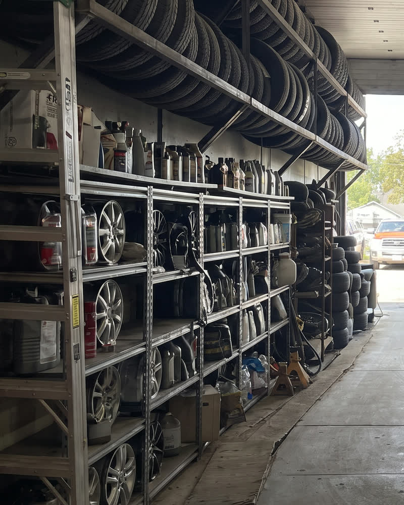 A technician mounting a tire onto a wheel rim on a shop lift