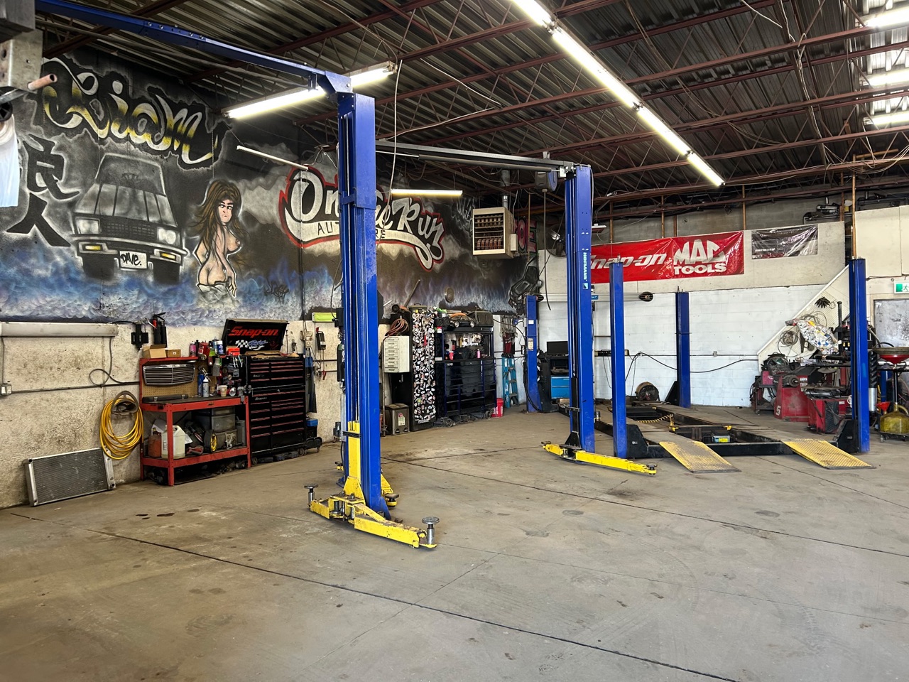 The main floor at On The Run: the mural, the lifts and the Snap-on and Mac banner